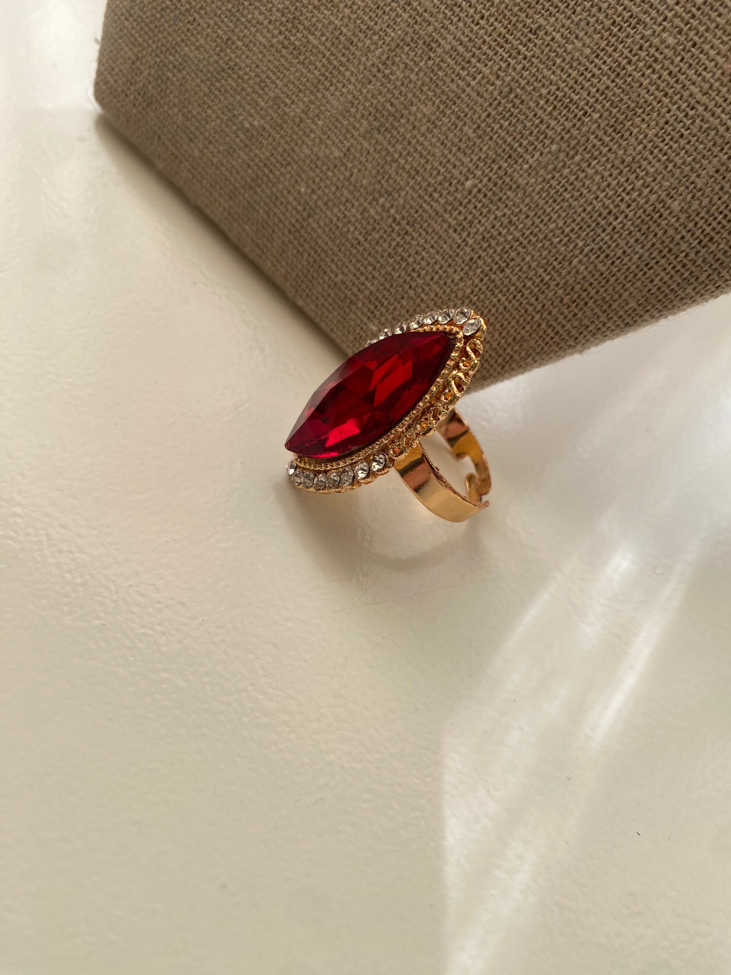 Anillo dorado con piedra fantasía roja